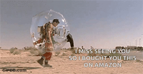 A Man In A Bubble Is Walking Down A Dirt Road . GIF