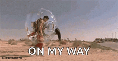 A Man In A Bubble Is Walking Down A Road With The Words `` On My Way '' Behind Him . GIF