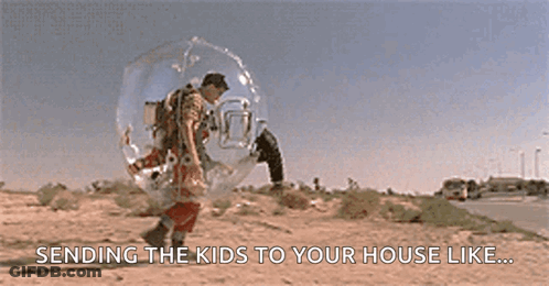 A Man In A Bubble Is Walking Down The Street . GIF