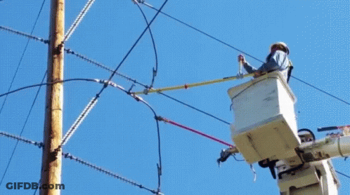 A Man In A Bucket Is Working On A Power Pole GIF