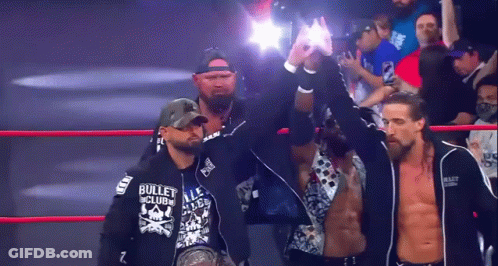 A Man In A Bullet Club Sweatshirt Stands In A Ring GIF