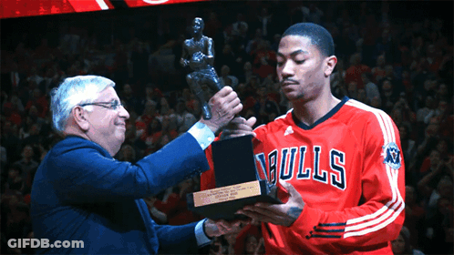A Man In A Bulls Jersey Holds A Trophy In Front Of A Crowd GIF
