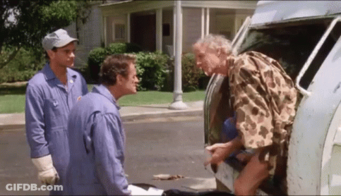 A Man In A Camo Shirt Is Getting Out Of A Van With Two Other Men Standing Behind Him . GIF