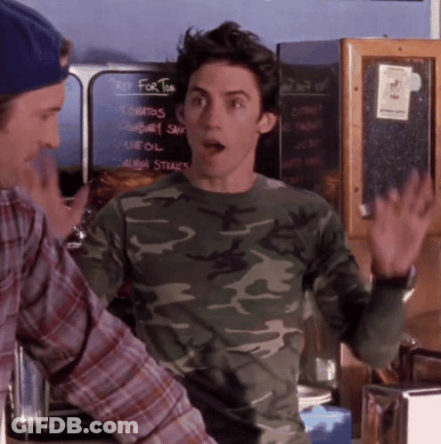A Man In A Camo Shirt Is Standing In Front Of A Chalkboard That Says Key For Tom GIF