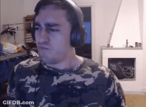 A Man In A Camo Shirt Is Wearing Headphones And Making A Face GIF