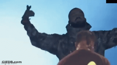 A Man In A Camouflage Jacket Is Making A Heart Shape With His Hands GIF