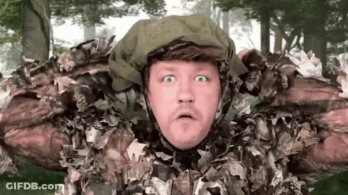 A Man In A Camouflage Outfit Is Making A Surprised Face . GIF