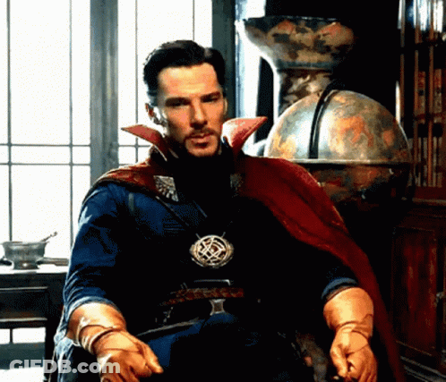 A Man In A Cape And Gloves Is Sitting In Front Of A Window . GIF