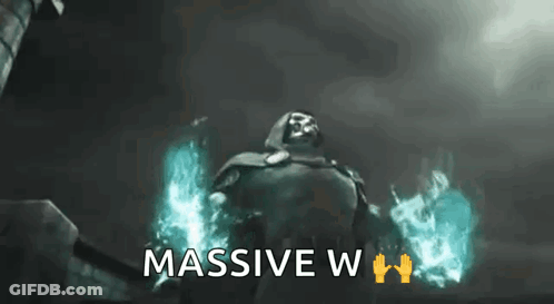 A Man In A Cape Is Standing In Front Of A Building With The Words `` Massive W '' Written Below Him . GIF