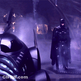 A Man In A Cape Is Standing In Front Of A Purple Car GIF