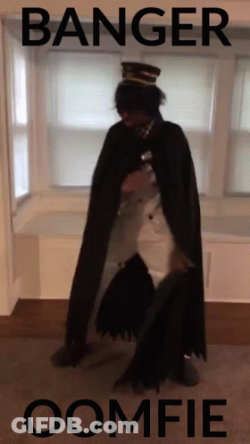 A Man In A Cape Is Standing In Front Of A Window With The Words Banger Oomfie Written On The Bottom GIF