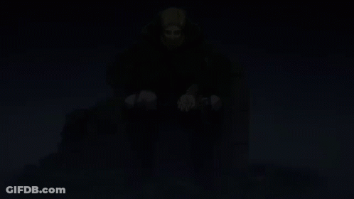 A Man In A Cape Sits On A Throne With His Hands In His Pockets GIF
