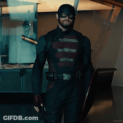 A Man In A Captain America Costume Holds A Shield And A Gun GIF