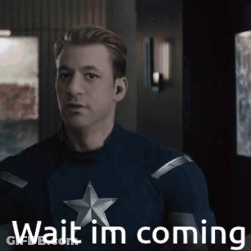A Man In A Captain America Costume Is Standing In A Room And Says Wait I 'M Coming . GIF