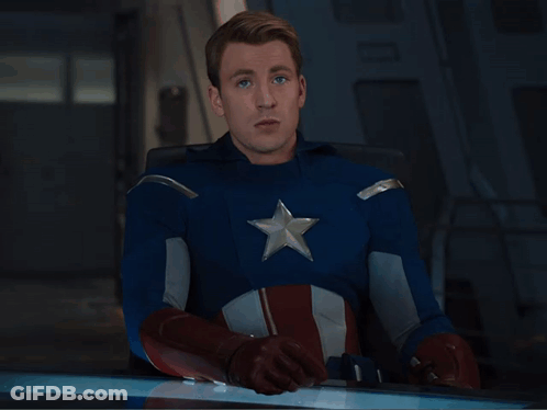 Man In Captain America Costume Sitting At Table GIF