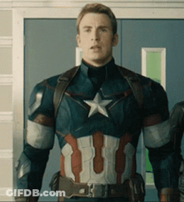A Man In A Captain America Suit Is Standing In Front Of A Door . GIF