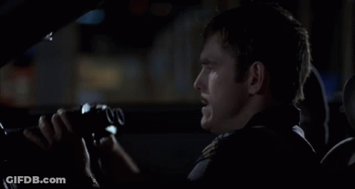 A Man In A Car Is Looking Through Binoculars With The Number 00 On The Lens GIF