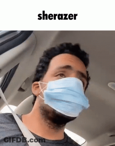 A Man In A Car Wearing A Face Mask With The Word Sherazer Above Him GIF