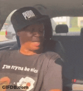 A Man In A Car Wearing A Puro Hat And A Shirt That Says I 'M Tryna Be Nice GIF