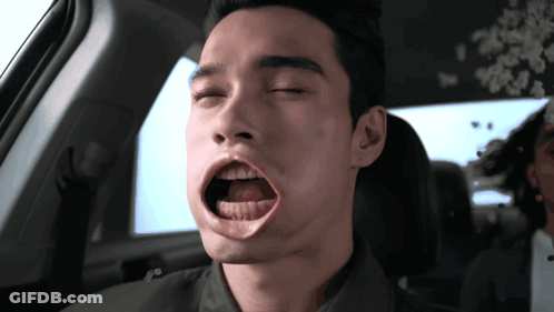 A Man In A Car With His Eyes Closed And His Mouth Open GIF