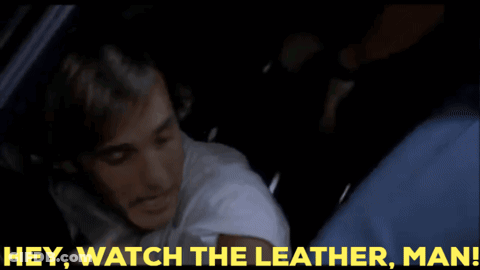 A Man In A Car With The Words Hey Watch The Leather Man Behind Him GIF