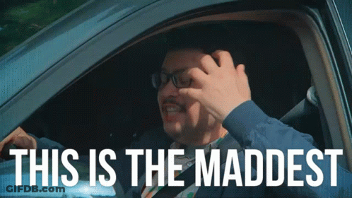 A Man In A Car With The Words This Is The Maddest GIF