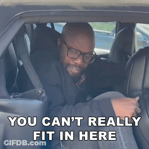 A Man In A Car With The Words " You Can T Really Fit In Here " GIF