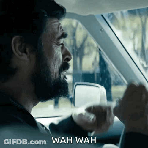 A Man In A Car With Wah Wah Written On The Bottom Right GIF