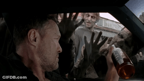 A Man In A Car With Zombies Behind Him And A Sign That Says Tobacco On It GIF
