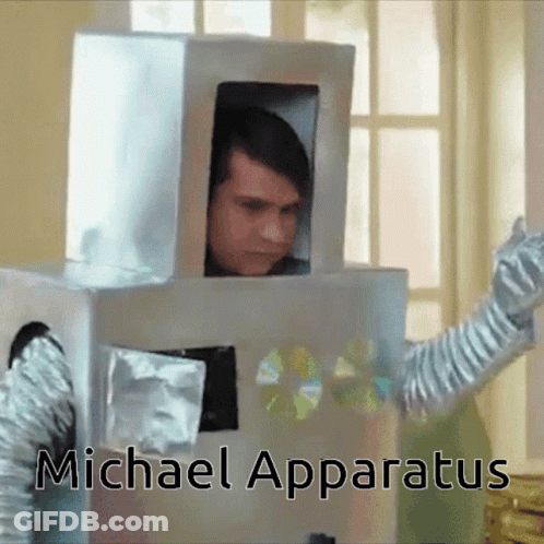 A Man In A Cardboard Robot Costume With The Name Michael Apparatus On The Bottom Right GIF