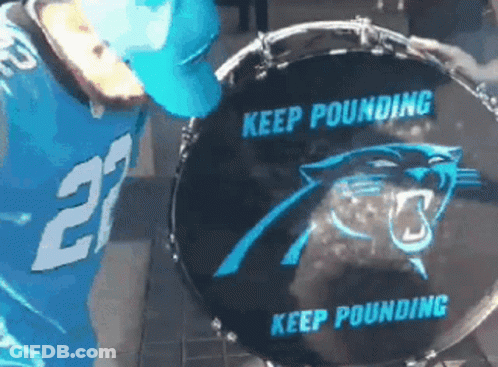 A Man In A Carolina Panthers Jersey Is Playing A Drum GIF