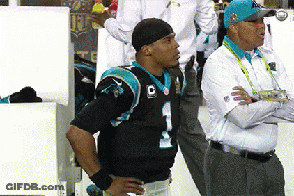 A Man In A Carolina Panthers Jersey Stands Next To A Man In A White Shirt GIF