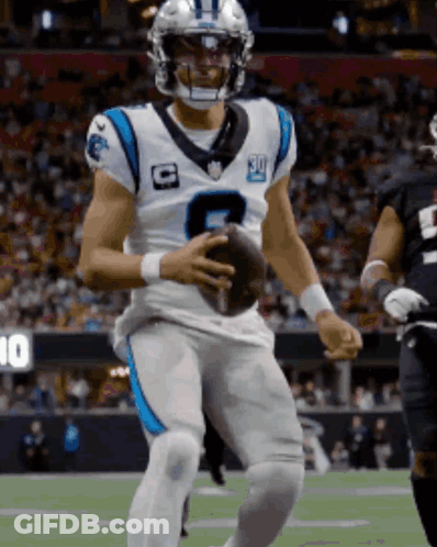 A Man In A Carolina Panthers Uniform Holds A Football GIF