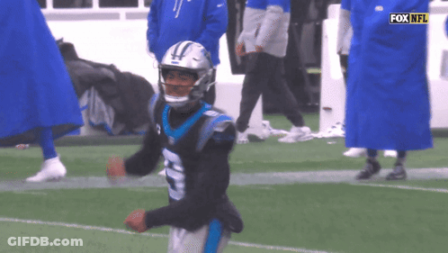 A Man In A Carolina Panthers Uniform Is Running On The Field GIF