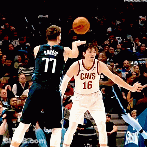 A Man In A Cavs Jersey Throws A Basketball At Another Man GIF