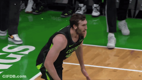 A Man In A Celtics Jersey Is Standing On A Basketball Court GIF