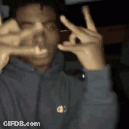 A Man In A Champion Hoodie Is Making A Peace Sign GIF