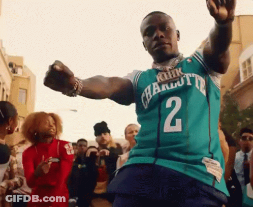 A Man In A Charlotte Jersey Is Dancing In Front Of A Crowd . GIF