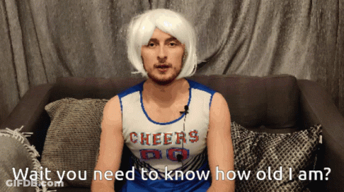 A Man In A Cheerleader Costume Is Sitting On A Couch GIF