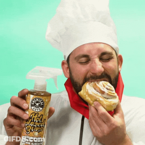 A Man In A Chef 'S Hat Is Eating A Cinnamon Roll While Holding A Bottle Of Chemical Guys GIF