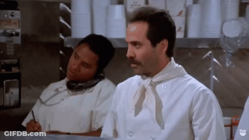 A Man In A Chef 'S Uniform Is Talking On A Cell Phone GIF