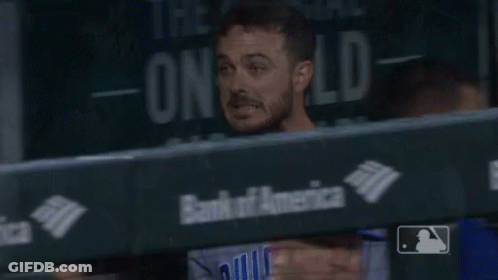 A Man In A Chicago Baseball Uniform Stands In A Dugout GIF