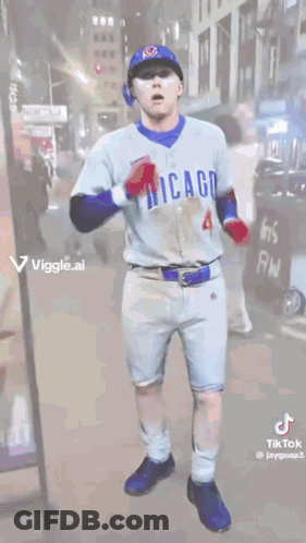 A Man In A Chicago Cubs Uniform Is Dancing On A Street . GIF