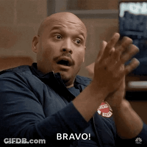 A Man In A Chicago Fire Department Jacket Applauds GIF
