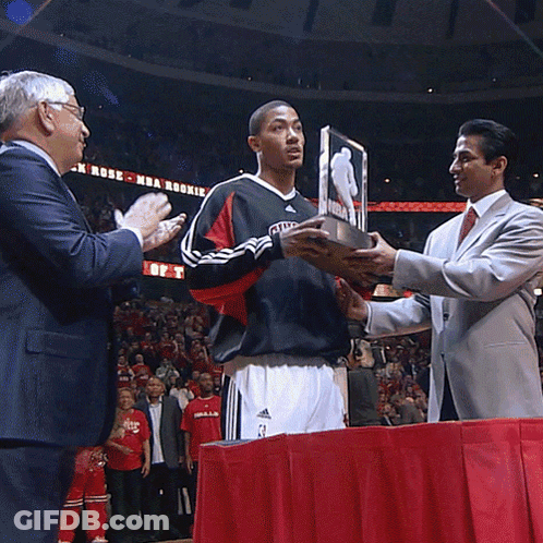 A Man In A Chicago Jersey Holds A Trophy GIF