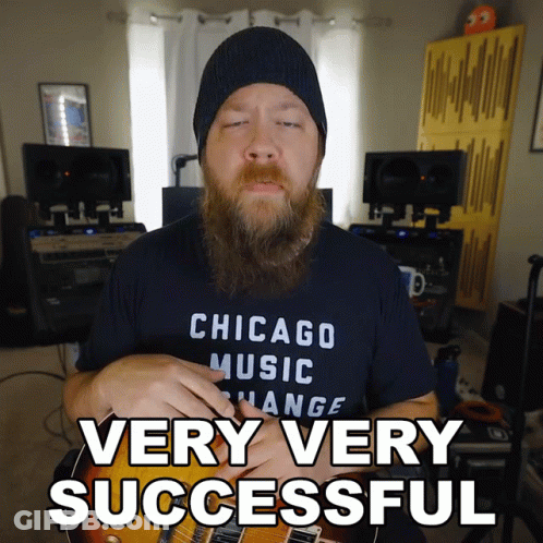 A Man In A Chicago Music Change Shirt Is Holding A Guitar GIF