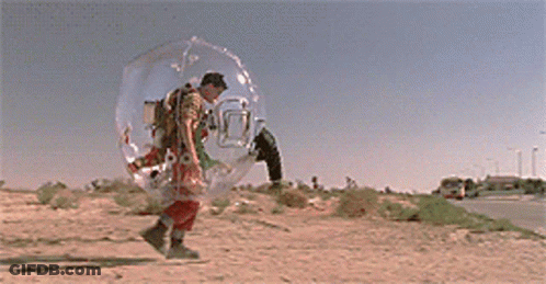 A Man In A Clear Bubble Walking Down A Street GIF
