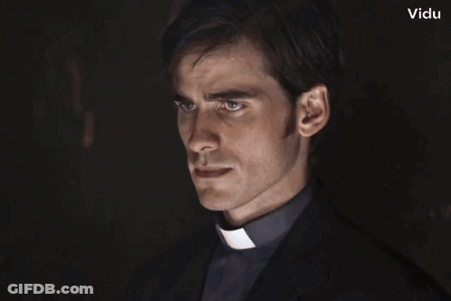 A Man In A Clergy Collar Looks Like A Vampire With Vidu In The Corner GIF