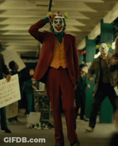 A Man In A Clown Costume Is Holding A Sign That Says " A Few Dollars More " GIF
