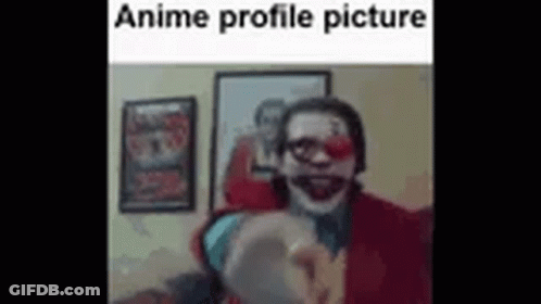 A Man In A Clown Costume Is Pointing At The Camera In A Room . GIF